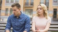 Upset couple sitting next to each other, angry guy jealous, girl about to cry Royalty Free Stock Photo