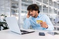 Upset and deceived businessman inside office trying to transfer money online, nervous man holding bank credit card, got Royalty Free Stock Photo