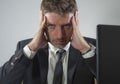 Upset and depressed businessman at office desk - young unhappy man working frustrated suffering stress and depression as employee Royalty Free Stock Photo