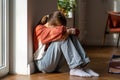 Upset depressed teenage girl sitting alone on floor and crying Royalty Free Stock Photo