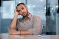 Upset disappointed and sad looking at web camera, man unhappy on online video meeting sitting at table inside office at Royalty Free Stock Photo