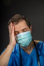 Upset / distraught doctor wearing surgical mask and stethoscope. Royalty Free Stock Photo