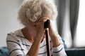 Upset mature woman with cane feel lonely at home