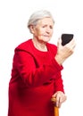 Upset elderly woman using touch screen mobile