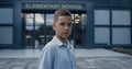 Upset elementary age boy standing at schoolyard closeup. Portrait unhappy pupil. Royalty Free Stock Photo