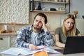 Upset european millennial man with stubble and blonde woman pay bills and taxes with laptop in light kitchen Royalty Free Stock Photo