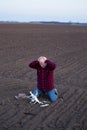 Upset farmer beside fallen drone in field Royalty Free Stock Photo