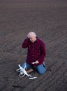 Upset farmer beside fallen drone in field Royalty Free Stock Photo