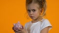 Upset female child shacking empty piggy bank, poor personal budget lack of money