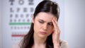 Upset female patient holding head, suffering high pressure, risk of losing sight Royalty Free Stock Photo