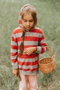 Upset or focused eight year old kid girl mushroom picker is seek for and picking mushrooms in the forest or woodland. child surviv Royalty Free Stock Photo