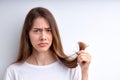 Upset frustrated woman holding hair in hands, need to cut them out, having split ends Royalty Free Stock Photo