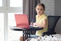 Upset girl doing homework online at home looked in frame