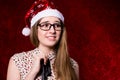 Upset girl with glasses in a santa hat looking to the side Royalty Free Stock Photo