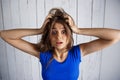 Upset girl holding hair in hands over white wooden background. Royalty Free Stock Photo