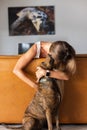 Upset girl hugging the dog and the dog licking her face.