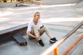 Upset girl sadly closing eyes holding her painful leg with skateboard near at skatepark isolated Royalty Free Stock Photo