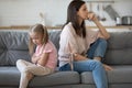 Upset girl sitting back to back with disappointed mother. Royalty Free Stock Photo
