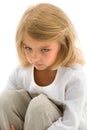 Upset Girl Sitting on the Floor with Her Knees Up and Folded Hands. Royalty Free Stock Photo