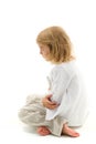 Upset Girl Sitting on the Floor with Her Knees Up and Folded Hands. Royalty Free Stock Photo