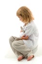 Upset Girl Sitting on the Floor with Her Knees Up and Folded Hands. Royalty Free Stock Photo