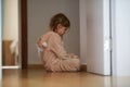 Upset girl sitting on floor near door Royalty Free Stock Photo