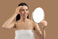 Upset half-naked woman looking at mirror and touching her face Royalty Free Stock Photo