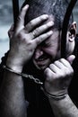 Upset handcuffed man imprisoned for crime, punished for serious villainy. Arrest, gangster, pain concept Royalty Free Stock Photo