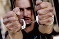 Upset handcuffed man imprisoned for crime, punished for serious villainy. Arrest, gangster, pain concept. Close up image