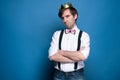 upset handsome man gold shiny homemade crown looking at camera with crossed arms