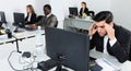 Upset Hispanic businessman worriedly looking at computer monitor in modern open plan office Royalty Free Stock Photo