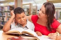 Upset Hispanic Young Boy and Famle Adult Studying At Library