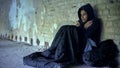 Upset homeless teenager wearing hoodie, feeling cold, indifference and poverty