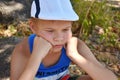 Upset kid boy sitting on the ground. Royalty Free Stock Photo