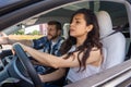 Scared woman is nervous during the driving exam while male instructor pointing on the road. Driving test, driver courses Royalty Free Stock Photo