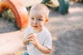 upset little baby boy outdoors infant portrait pain blanket park, ice-cream in hands
