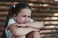 Upset little girl sitting near the wall Royalty Free Stock Photo