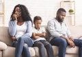 Upset little girl suffer from family conflict, sitting between parents. Royalty Free Stock Photo