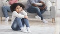 Upset little girl suffering from parents quarrels, sitting on floor alone Royalty Free Stock Photo