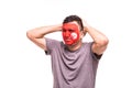 Upset loser fan support of Tunisia national team with painted face isolated on white background