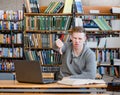 Upset male student with in library showing thumb down Royalty Free Stock Photo