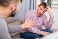 Man having unpleasant talk with colleague on couch