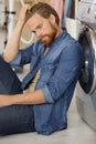 Upset man next to washing machine Royalty Free Stock Photo