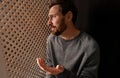 Upset man talking to priest during confession in booth, space for text Royalty Free Stock Photo