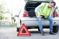 Upset man waiting after unexpected car breakdown