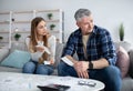 Upset mature couple having no money to pay bills at home, calculating income and expenditures, going through crisis Royalty Free Stock Photo