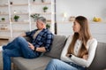 Upset mature woman and her husband sitting apart on couch at home after quarrel, feeling offended, having conflict Royalty Free Stock Photo