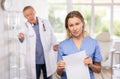 Upset middle-aged nurse standing with her back to angry doctor Royalty Free Stock Photo