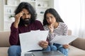Upset millennial indian spouses checking bills, reading documents Royalty Free Stock Photo