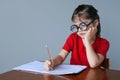 Upset nerdy child doing homework Royalty Free Stock Photo